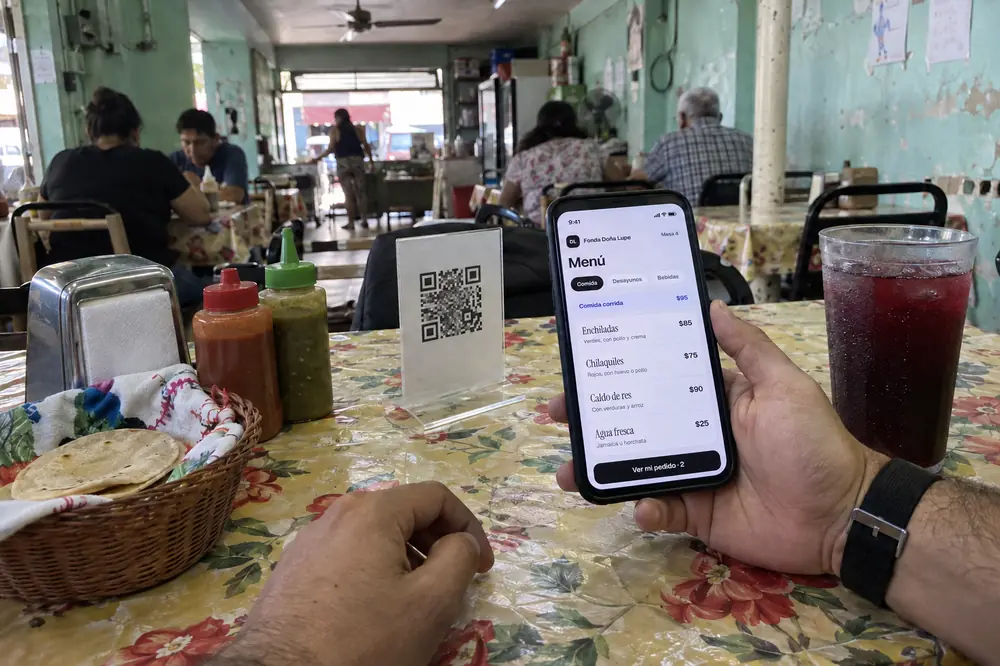 Ejemplo: en una fonda, un cliente ve el menú en su celular después de escanear el QR de la mesa